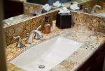 The bathroom features granite counter tops and custom wood cabinets